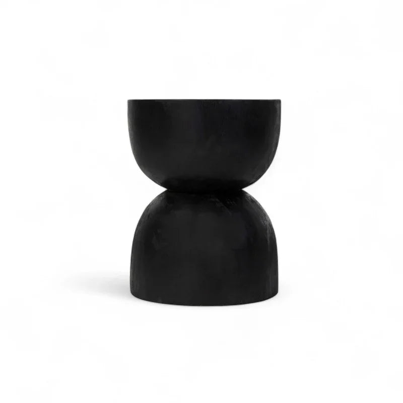 Black hand-carved wooden stool with sculptural hourglass design from Kayu Living