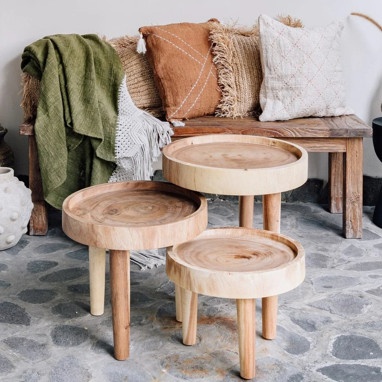 Handcrafted wooden tables and rustic bench with textured cushions and throw, Kayu Living style
