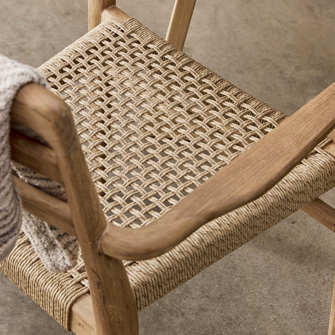 Set of two Verano teak dining chairs with armrests by Raw Materials, featuring natural wood finish and modern design.