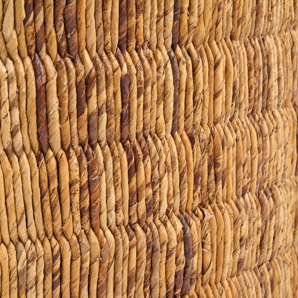 Close-up of the natural handwoven abaca texture on the Kayu Living Magani coffee table with warm tonal variations.