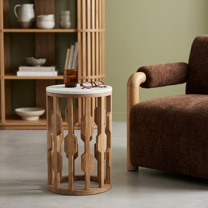 Kayu Living Atjeh side table with a round white marble top and an open geometric mango wood base in a living room.