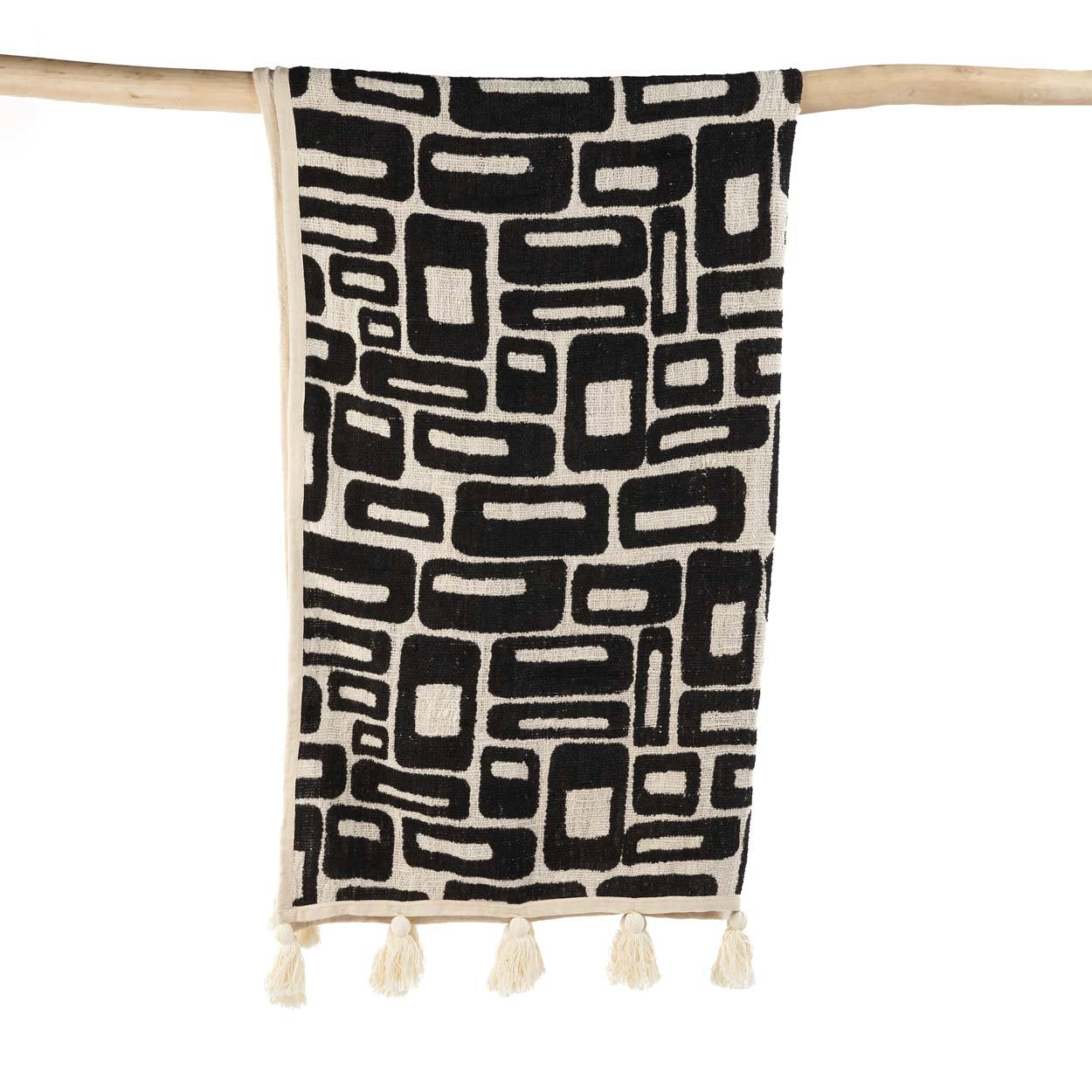 Kayu Living Aztec bed throw in natural black cotton with woven geometric patterns and decorative corner tassels.