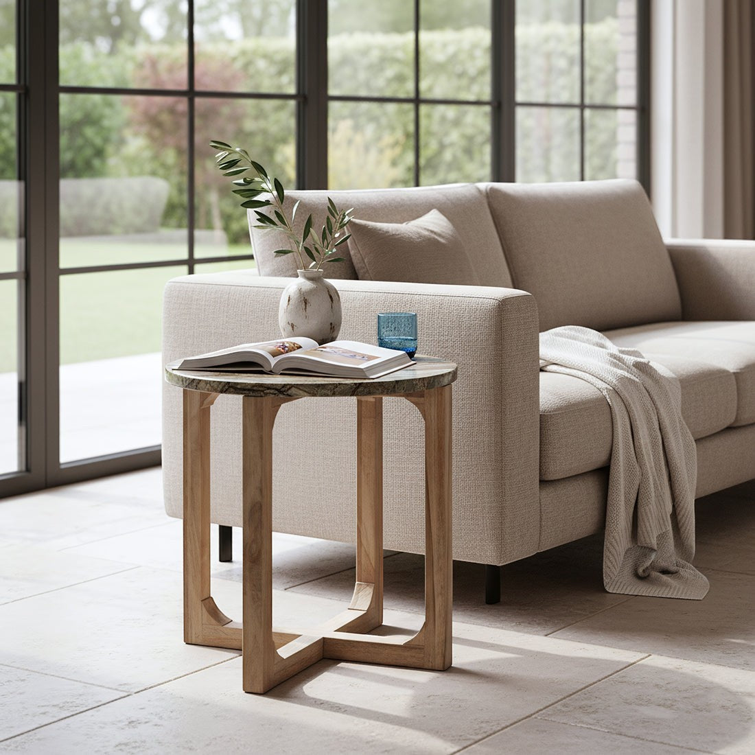 Kayu Living Bizar side table with a round marble top and crossed mango wood base in a bright living room.