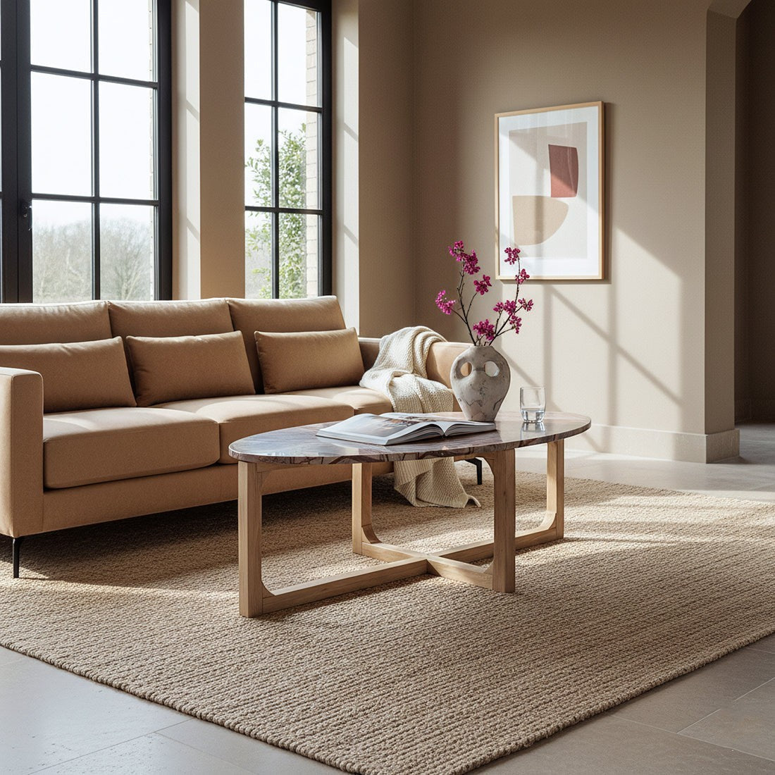 Kayu Living Bizar oval marble coffee table with light mango wood cross-frame in a sunlit modern living room