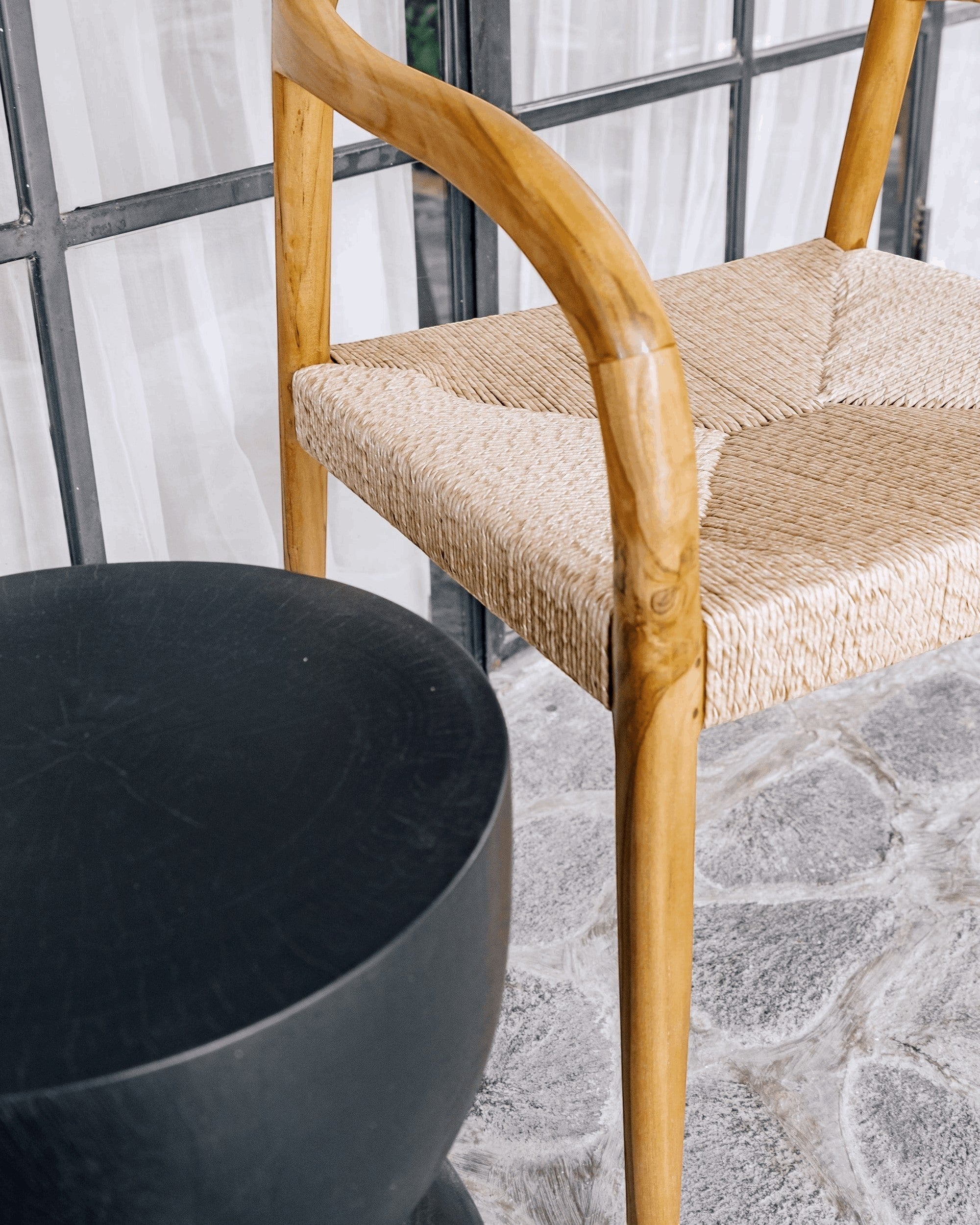 Kayu Living black hourglass stool made from solid suar wood with natural grain details, handcrafted by artisans in Java.