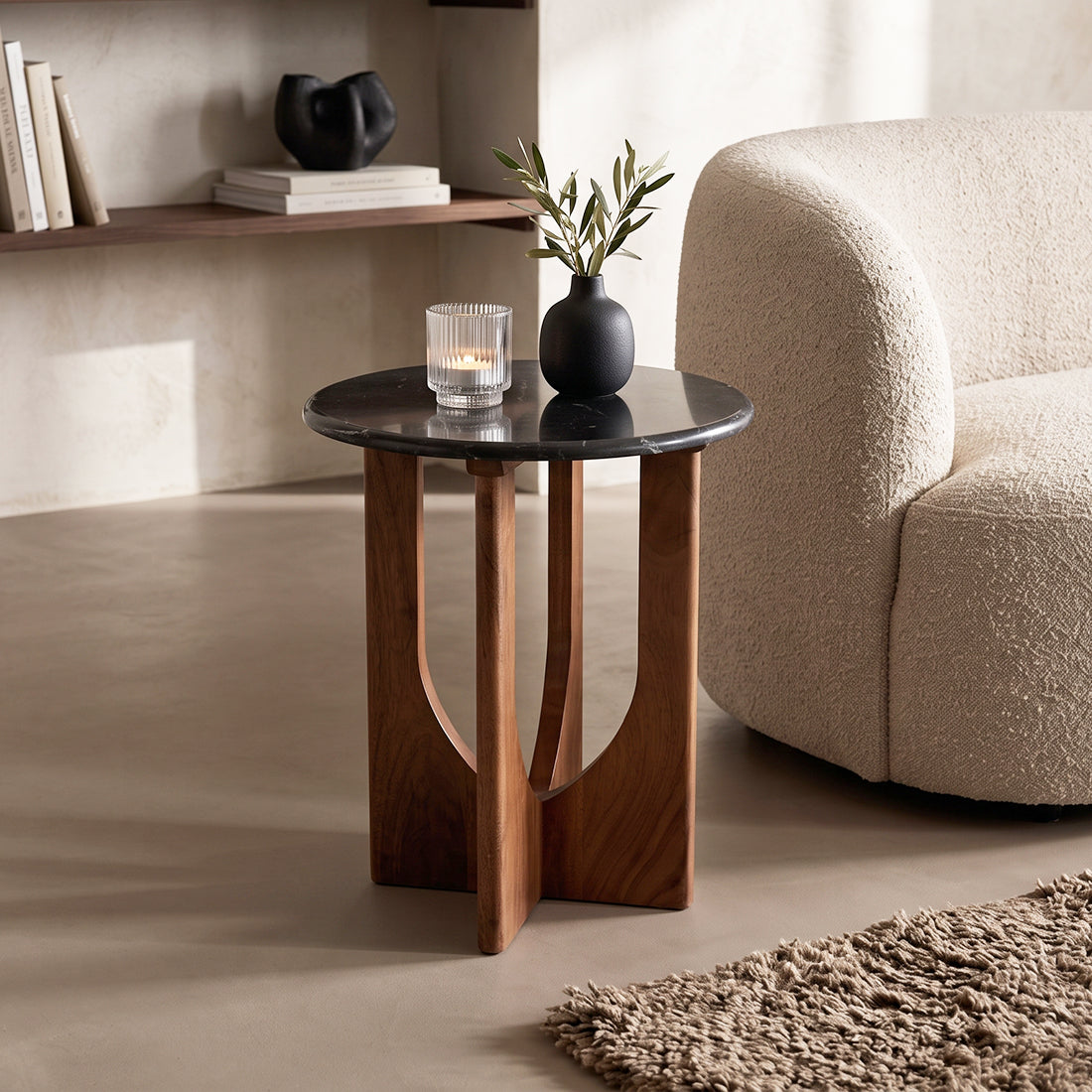 Kayu Living Brunei side table with a round black marble top and a dark mango wood cross base in a modern living room.