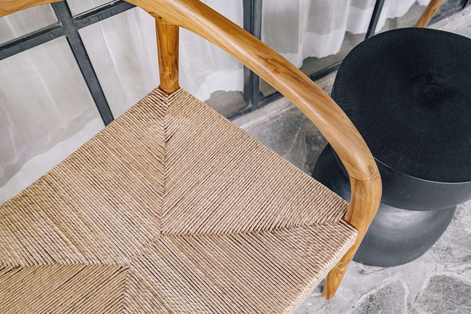 Kayu Living Cemagi chair with natural woven rope seat and curved teak frame, suitable for indoor/outdoor use.
