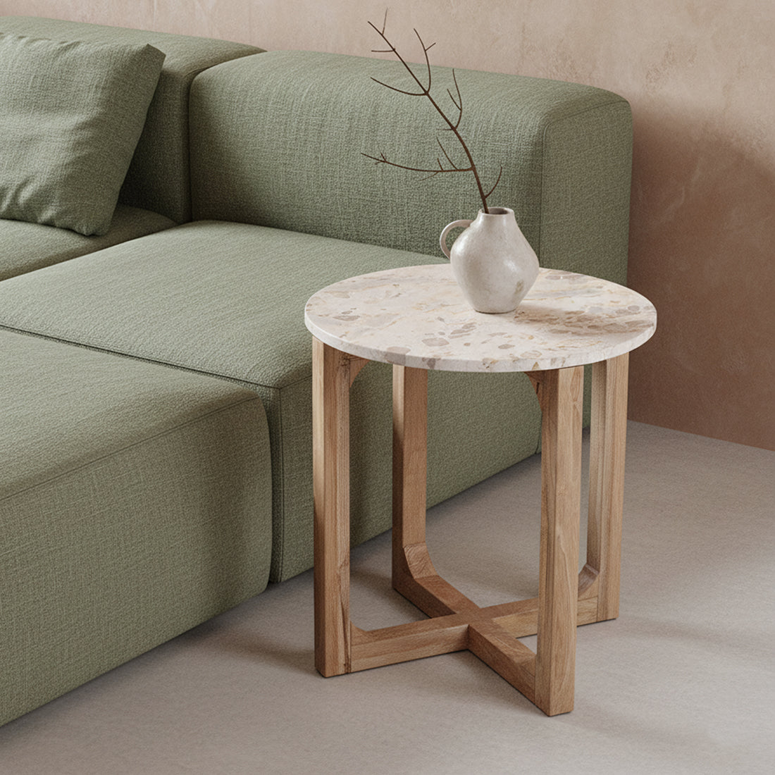 Kayu Living cream marble side table with a round top and open mango wood base next to a green sofa
