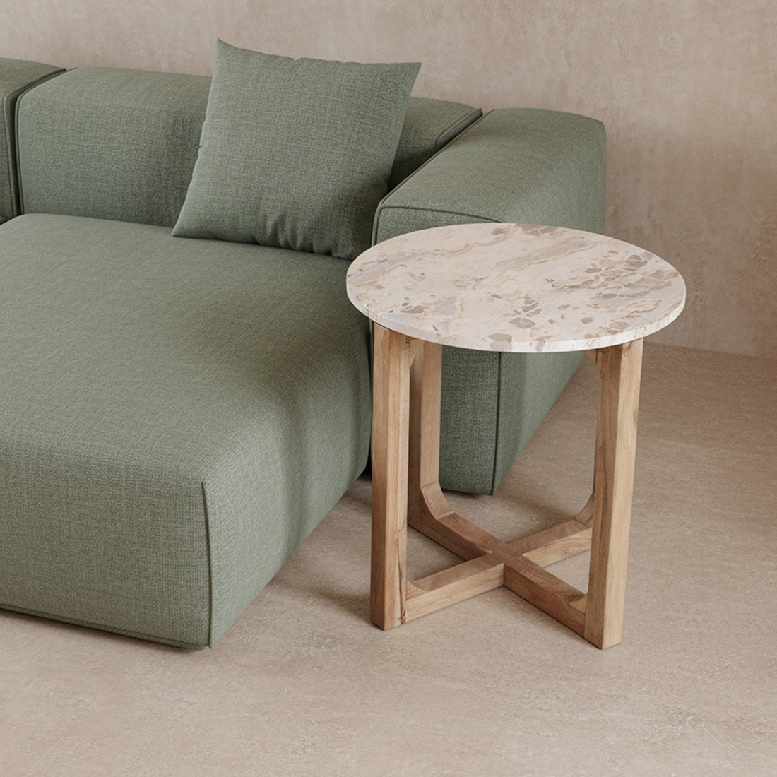 Kayu Living cream marble side table with a round top and open mango wood base next to a green sofa
