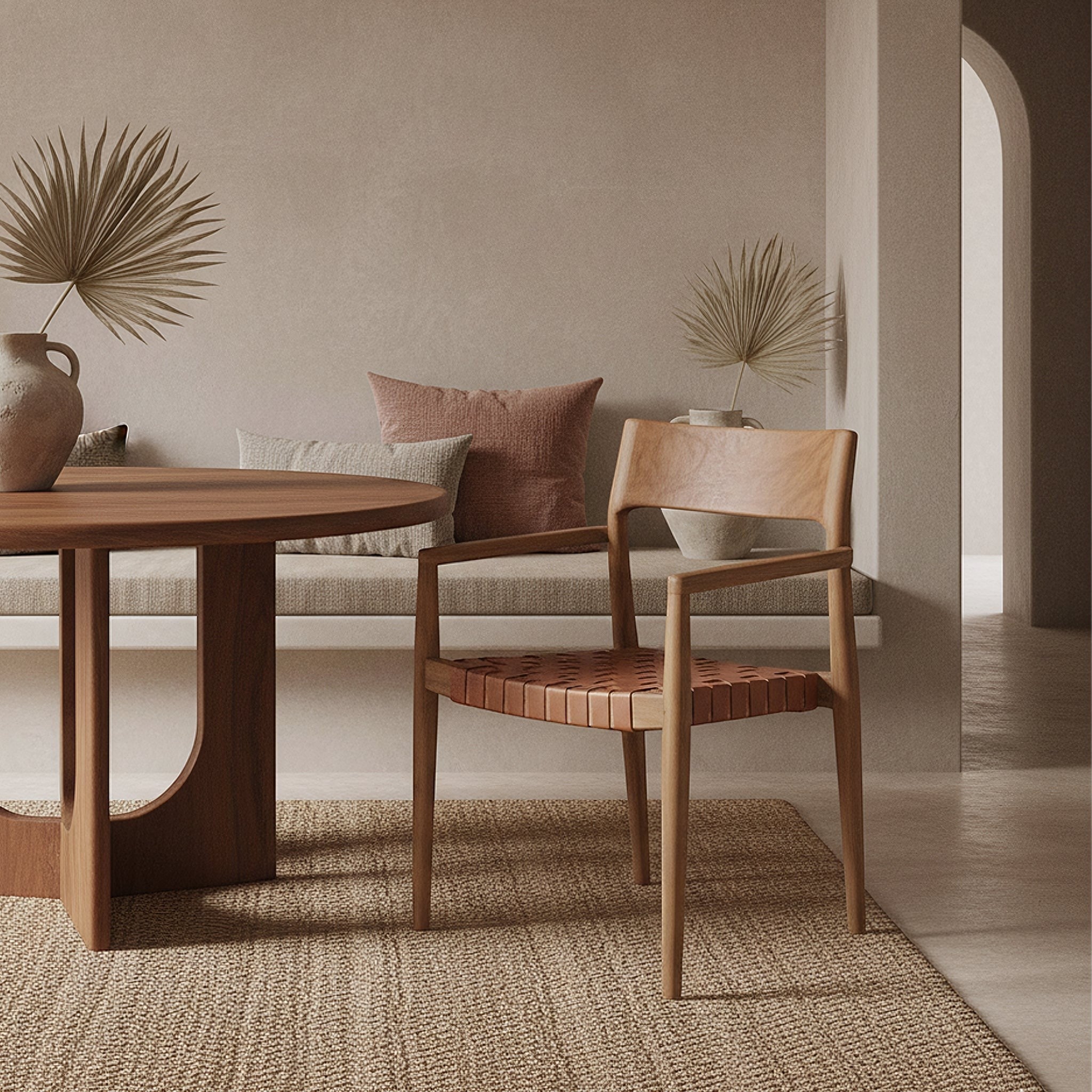 Kayu Living Freya brown teak dining chair with woven leather seat and armrests in a minimalist boho dining room.