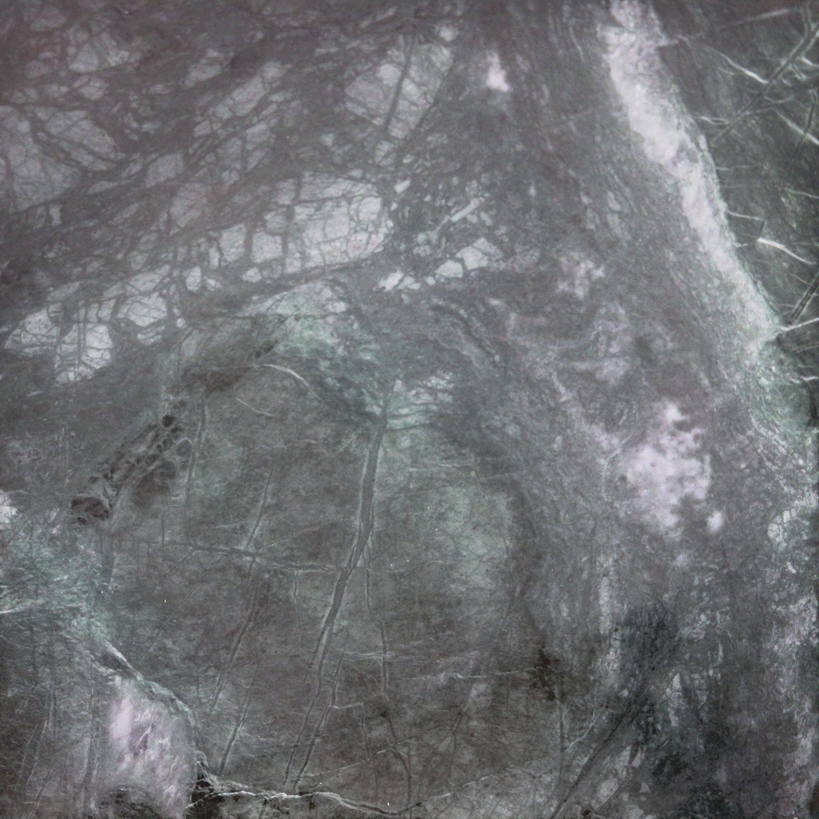 Close-up of Kayu Living green marble coffee table surface showing unique natural veining and polished stone texture.