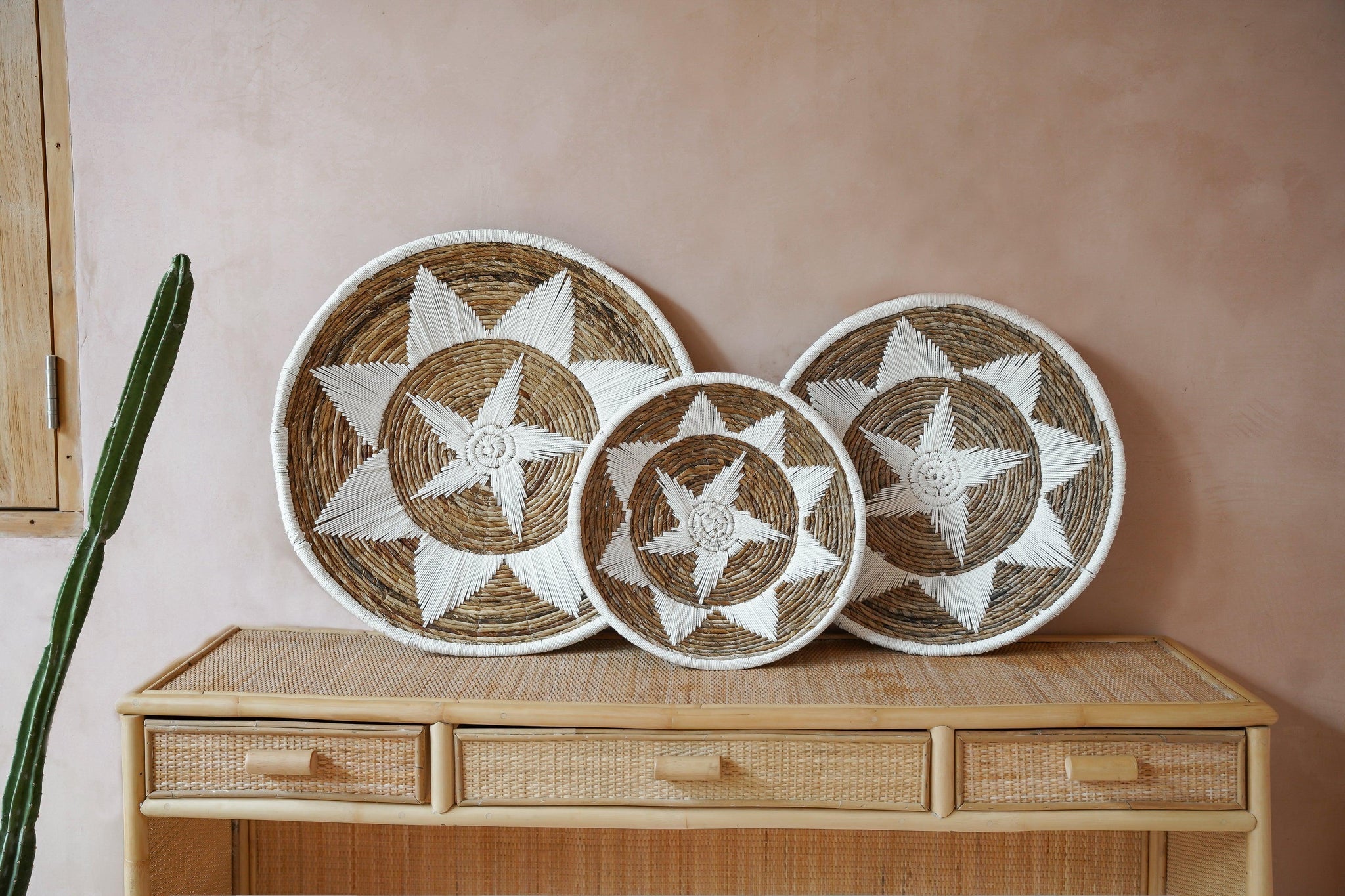 Kayu Living Uluwatu handmade banana-leaf and cotton wall baskets with brown and white star patterns on a rattan console