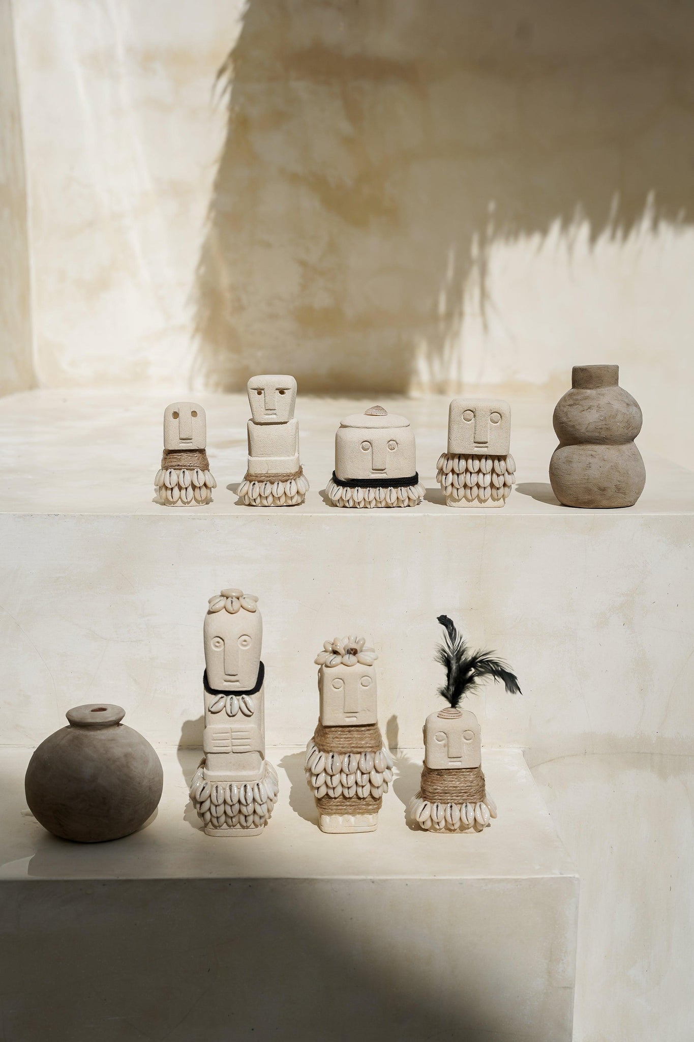 Kayu Living handmade natural stone figurines with boho shell and jute accents displayed on a tiered beige surface