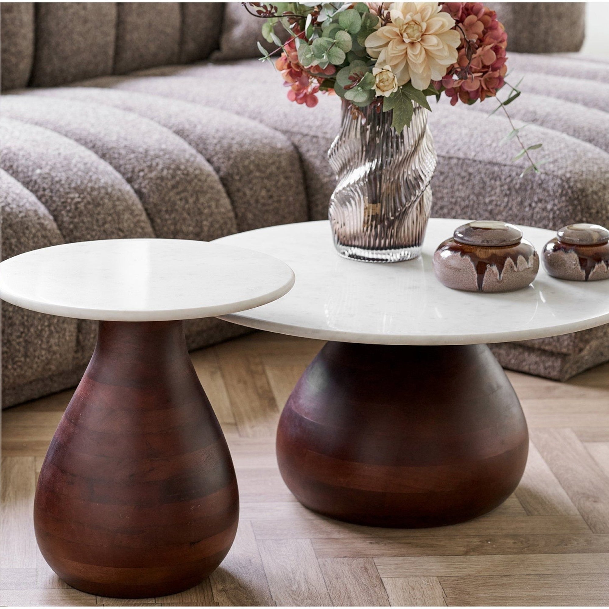 Kayu Living Heide side tables with dark brown mango wood bases and round white marble tops in a modern living room.