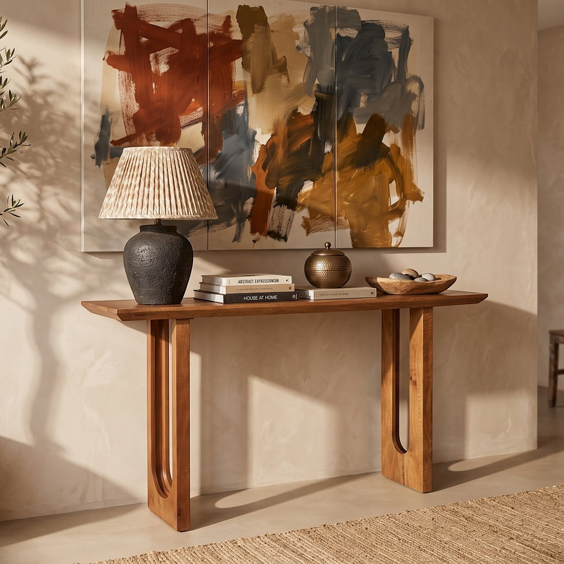 Kayu Living bullnose chamfered mango wood console table with unique grain, styled with a lamp and books in a hallway.
