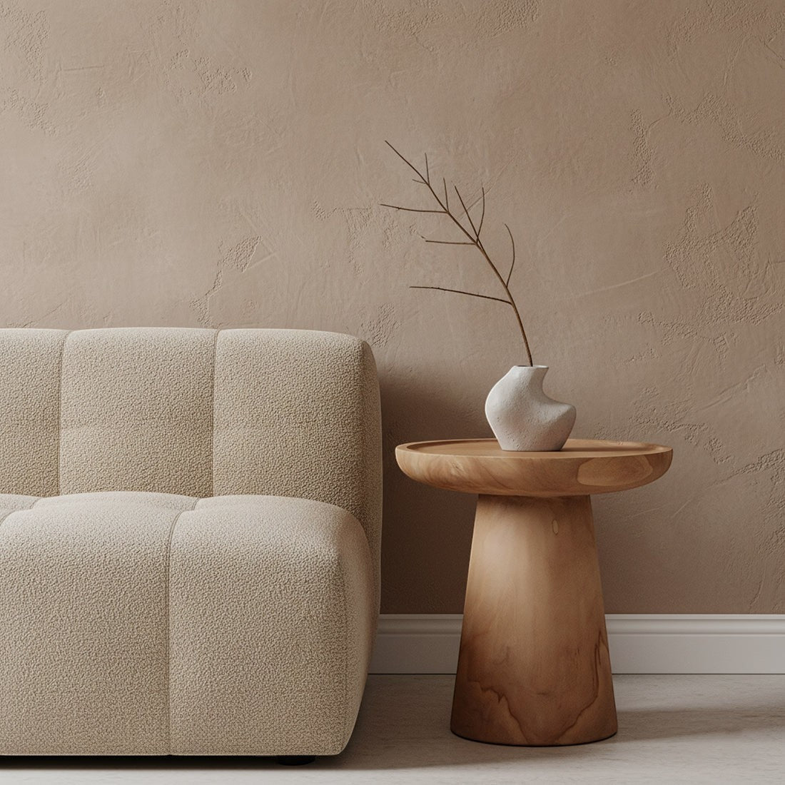 Kayu Living Nero Ray teak side table with a modern pedestal design, placed next to a beige textured sofa.