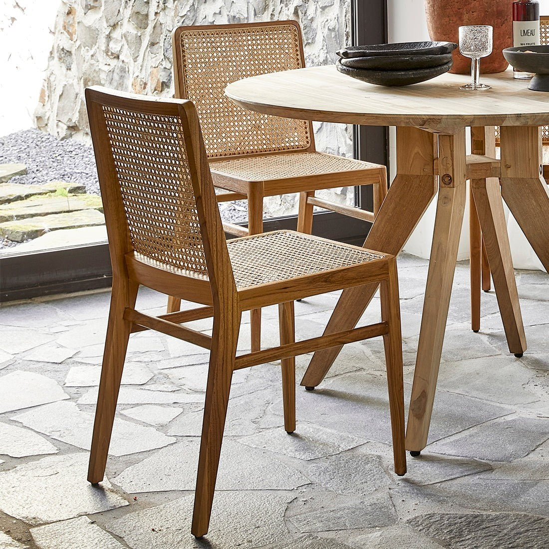Kayu Living Nova teak dining chairs with hand-woven rattan seats and backs in a natural wood finish.