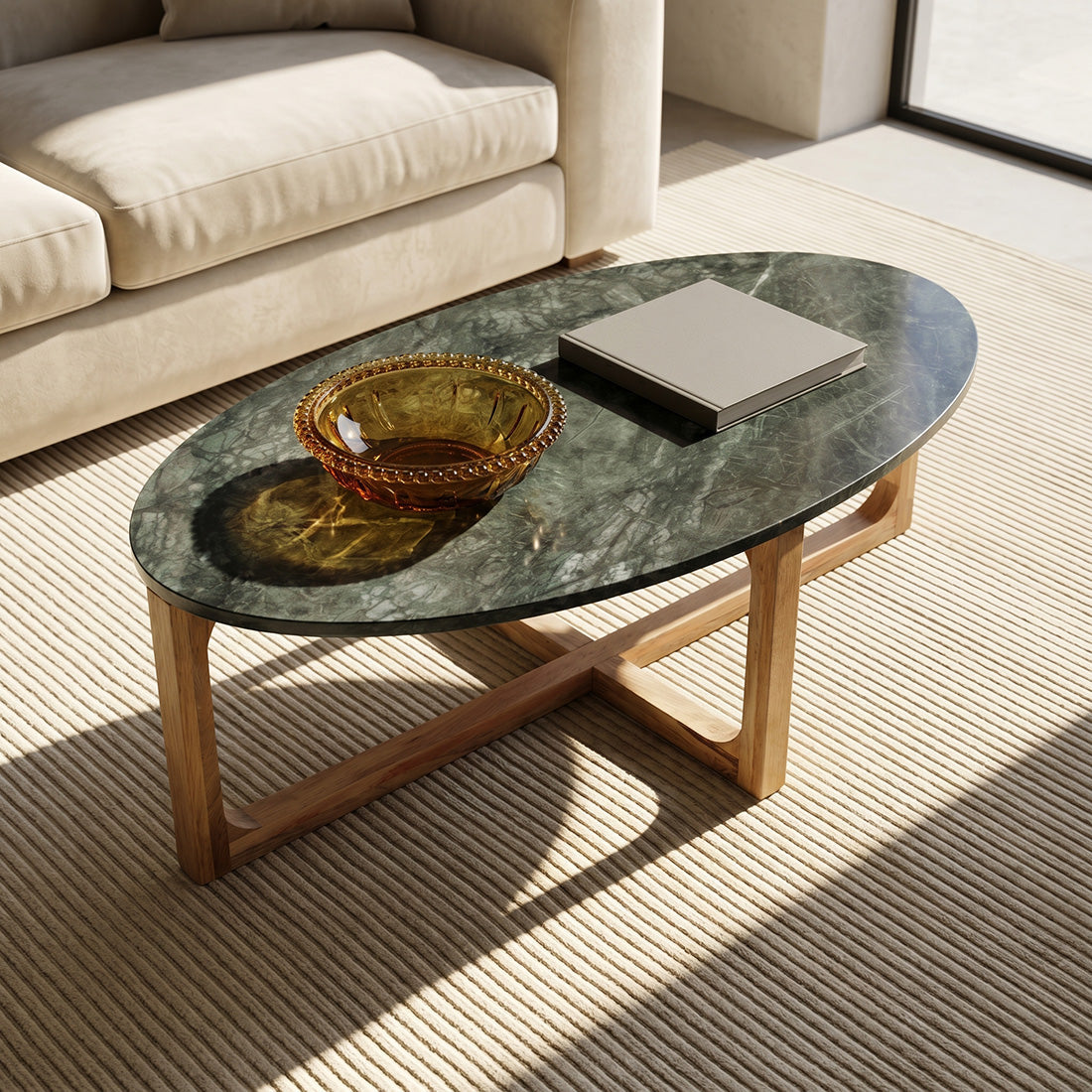 Kayu Living oval coffee table with a green marble top and sustainable mango wood base in a sunlit living room