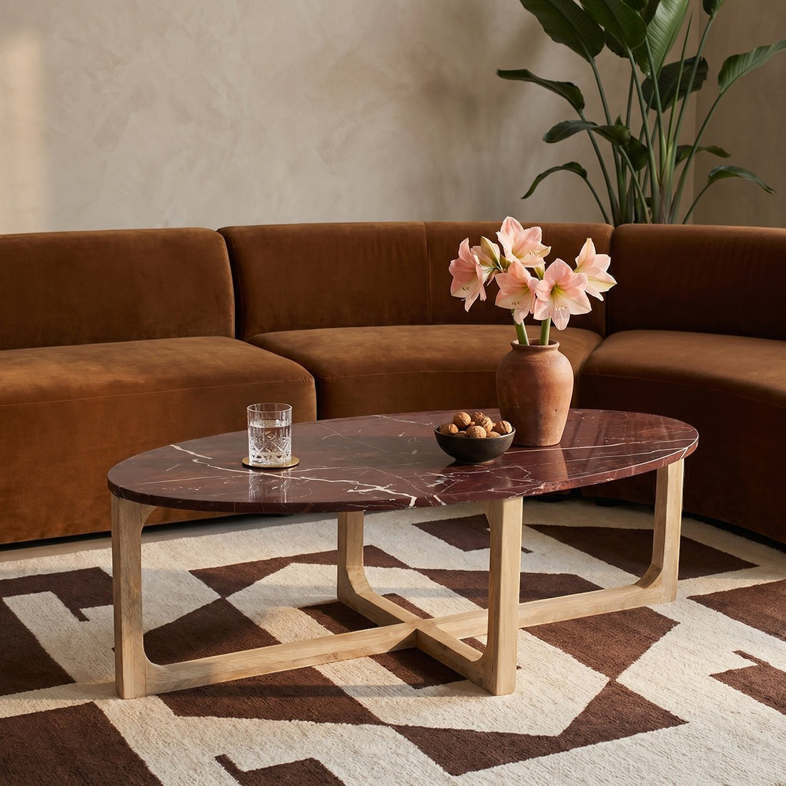 Kayu Living oval marble coffee table with bordeaux top and white veining on a natural mango wood base.