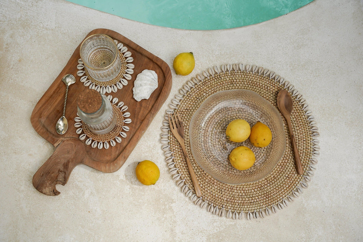 Kayu Living handcrafted brass pineapple spoon on a wooden serving board with shell-trimmed coasters and lemons