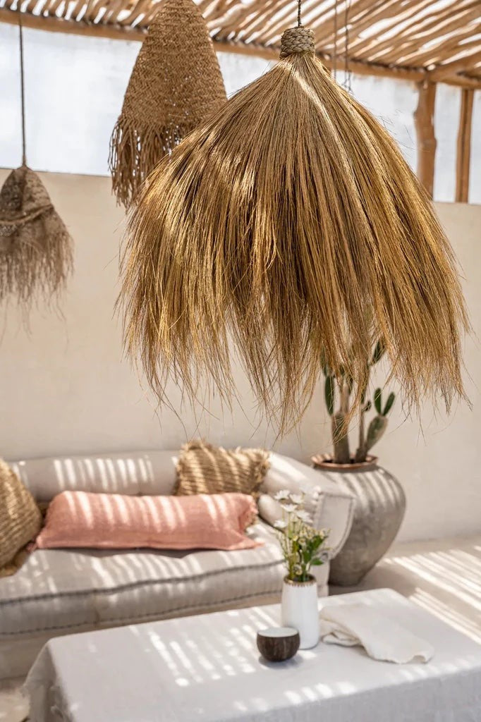 Kayu Living Rayung pendant lamp made of natural brown rayung grass with a flowing silhouette and fringed edges.