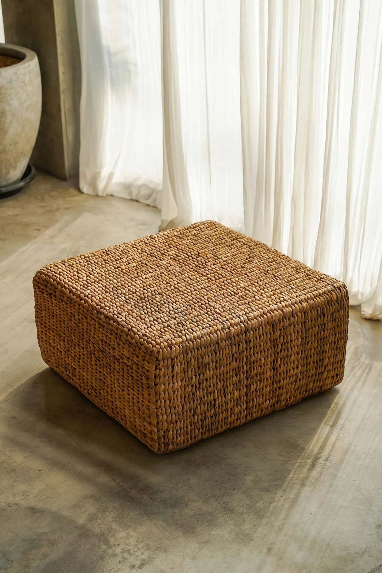 Kayu Living square water-hyacinth pouf in natural tan, featuring a durable woven texture for indoor or outdoor use.