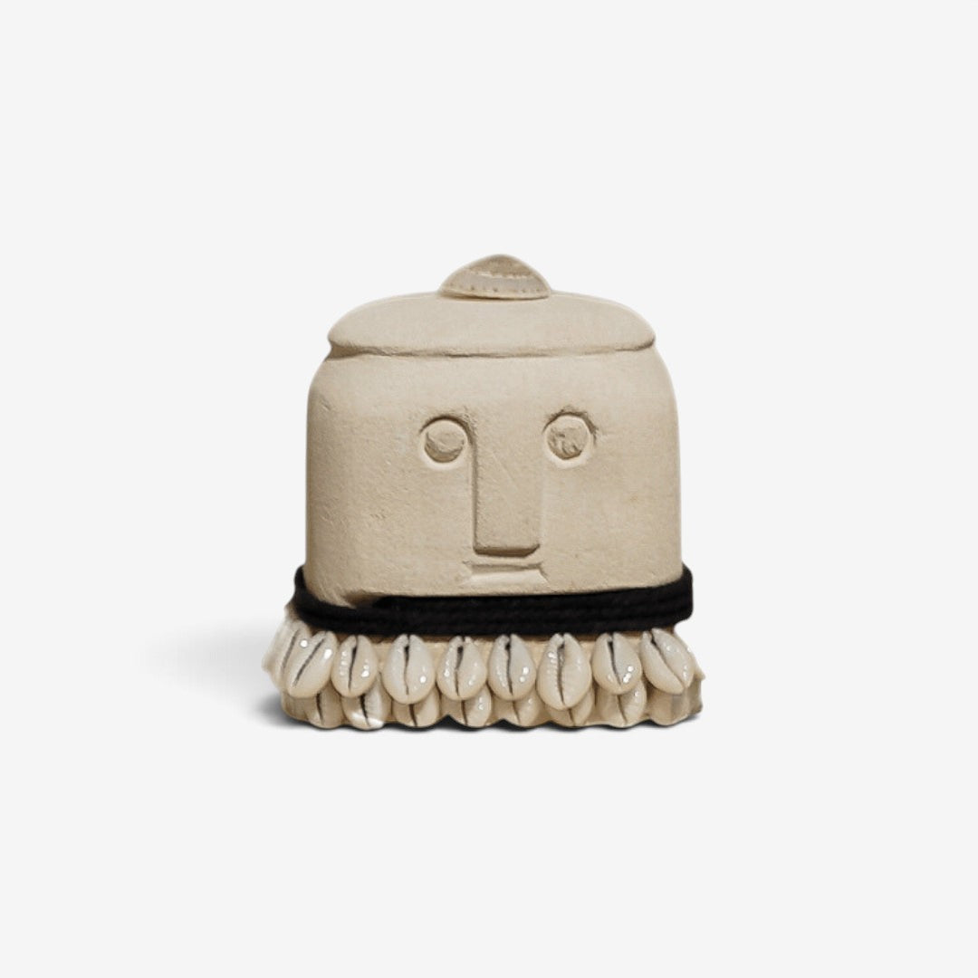 Kayu Living handmade stone figurine with a carved face, black cord, and shell trim in natural beige tones.