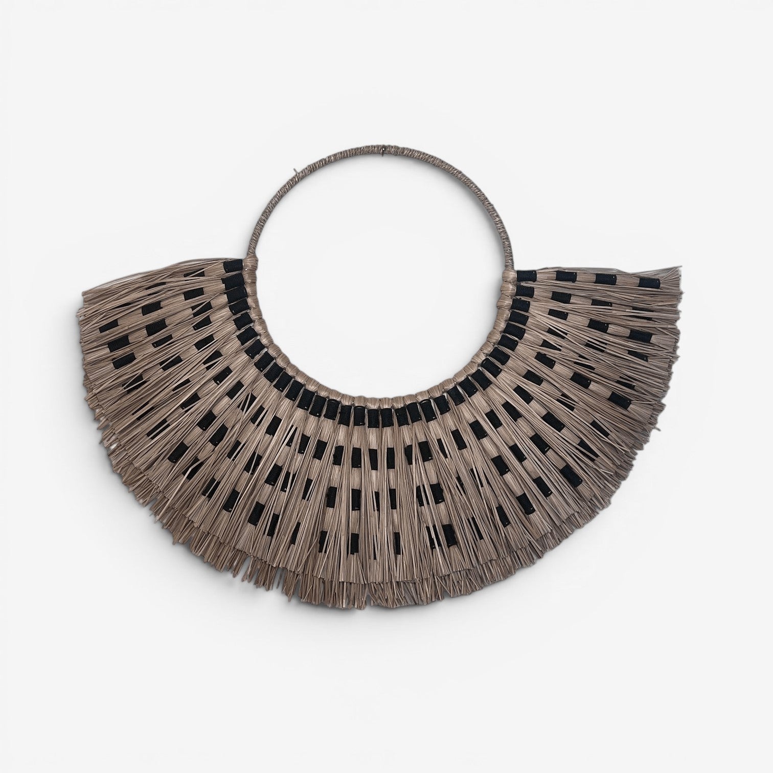 Kayu Living Sumba Natural wall decoration, handwoven beige organic fibers with black accents, circular fan shape.