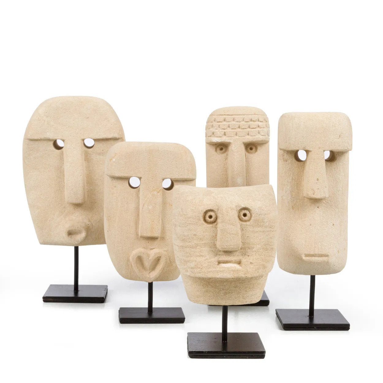 Kayu Living hand-carved sandstone Sumba stone statues on black metal stands, featuring unique tribal face designs.