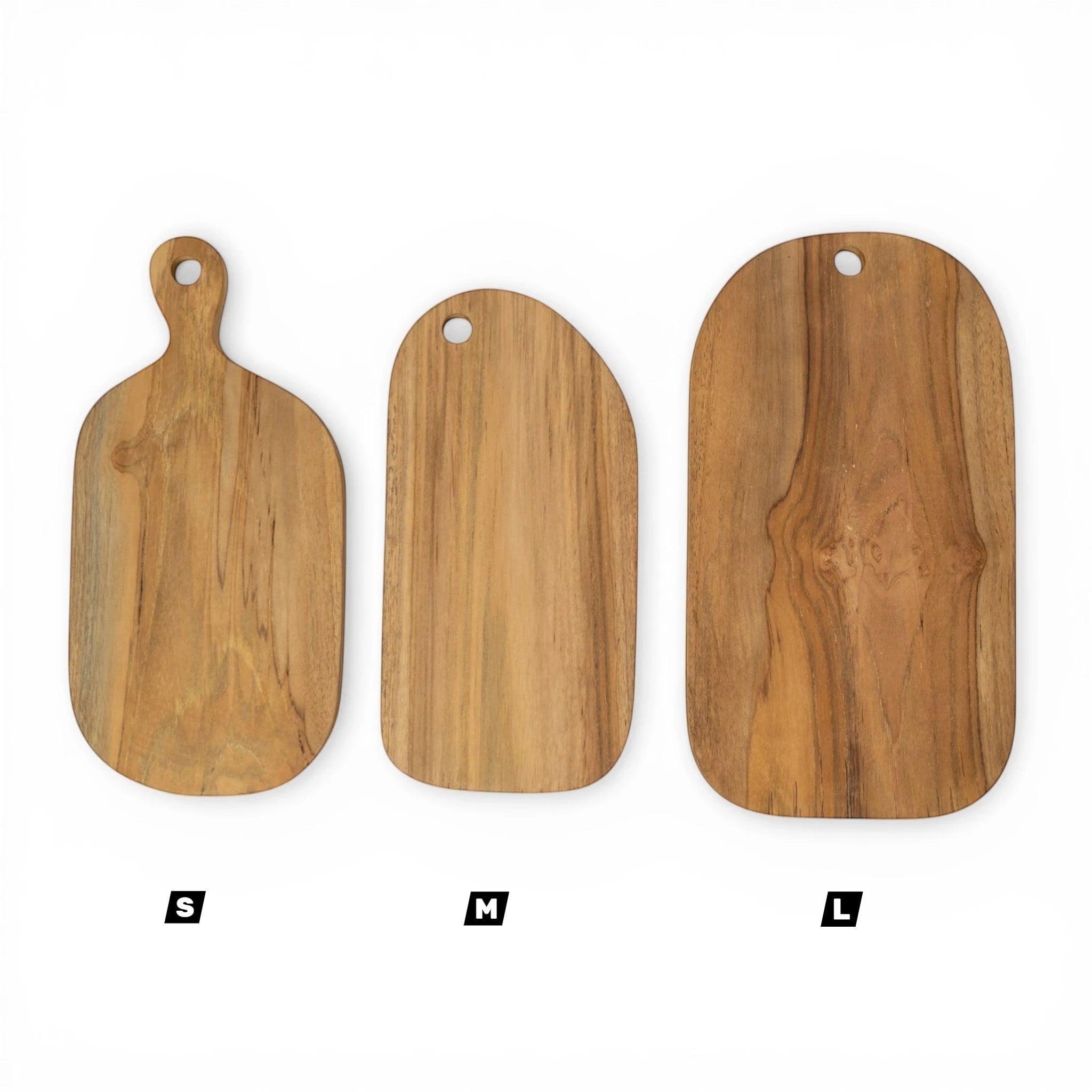 Kayu Living handcrafted teak wood cutting boards in small, medium, and large sizes. Natural wood grain, smooth finish, and hanging holes.