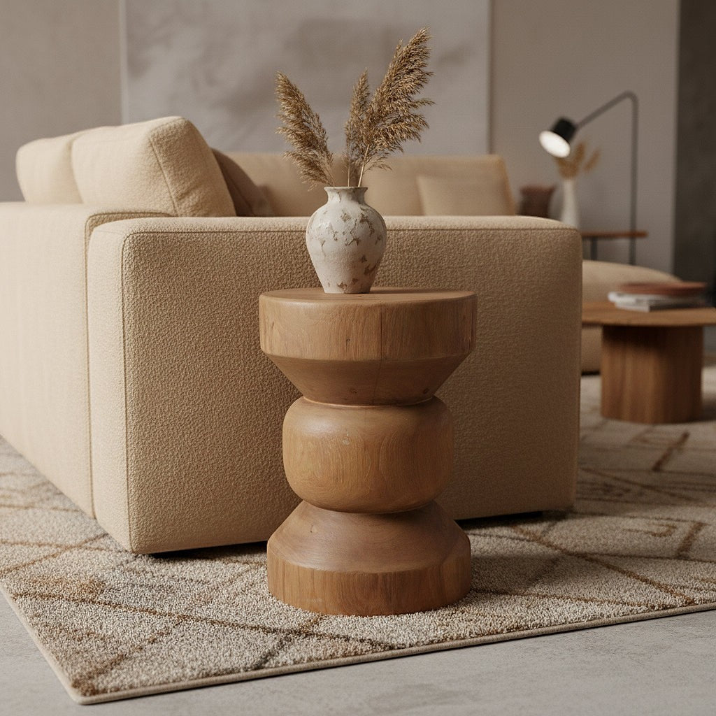 Kayu Living Forma Ritari solid teak side table with a stacked geometric design in a warm wood tone next to a sofa.