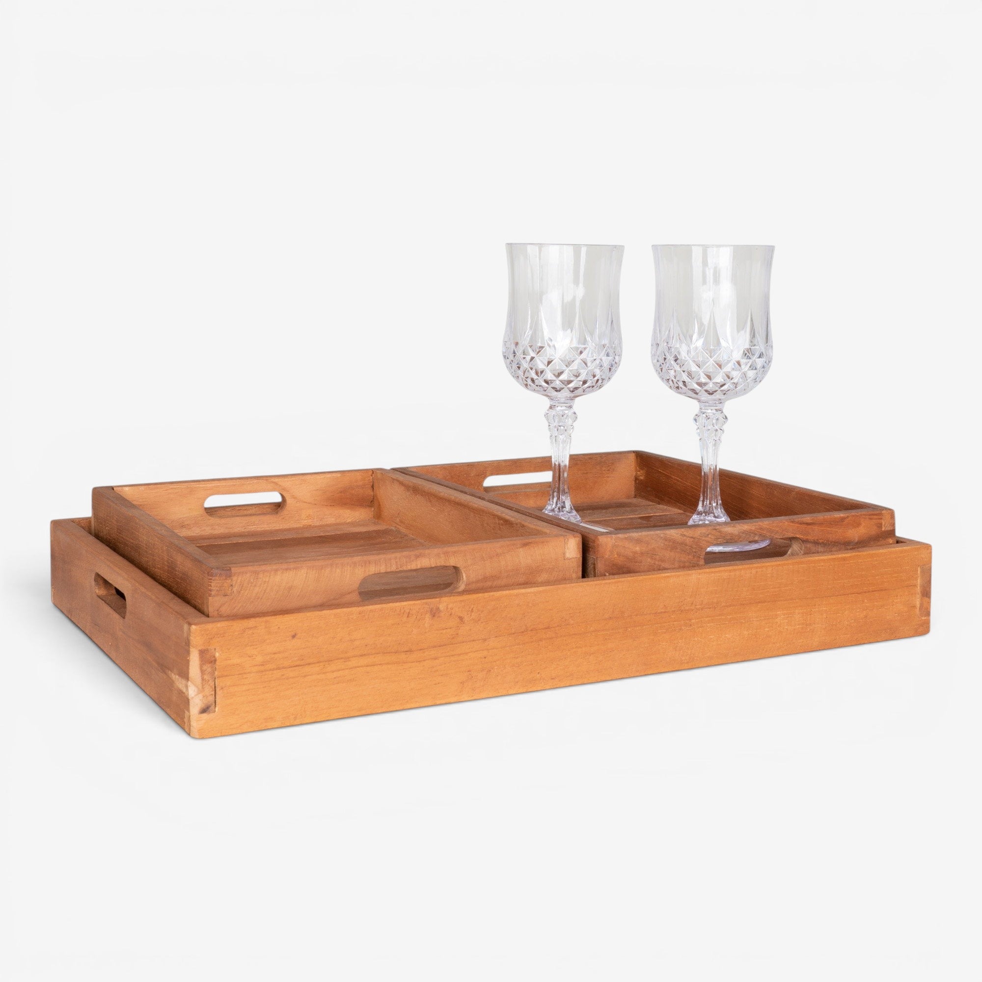 Kayu Living set of 3 natural teak serving trays with cut-out handles. Warm grain, smooth finish.
