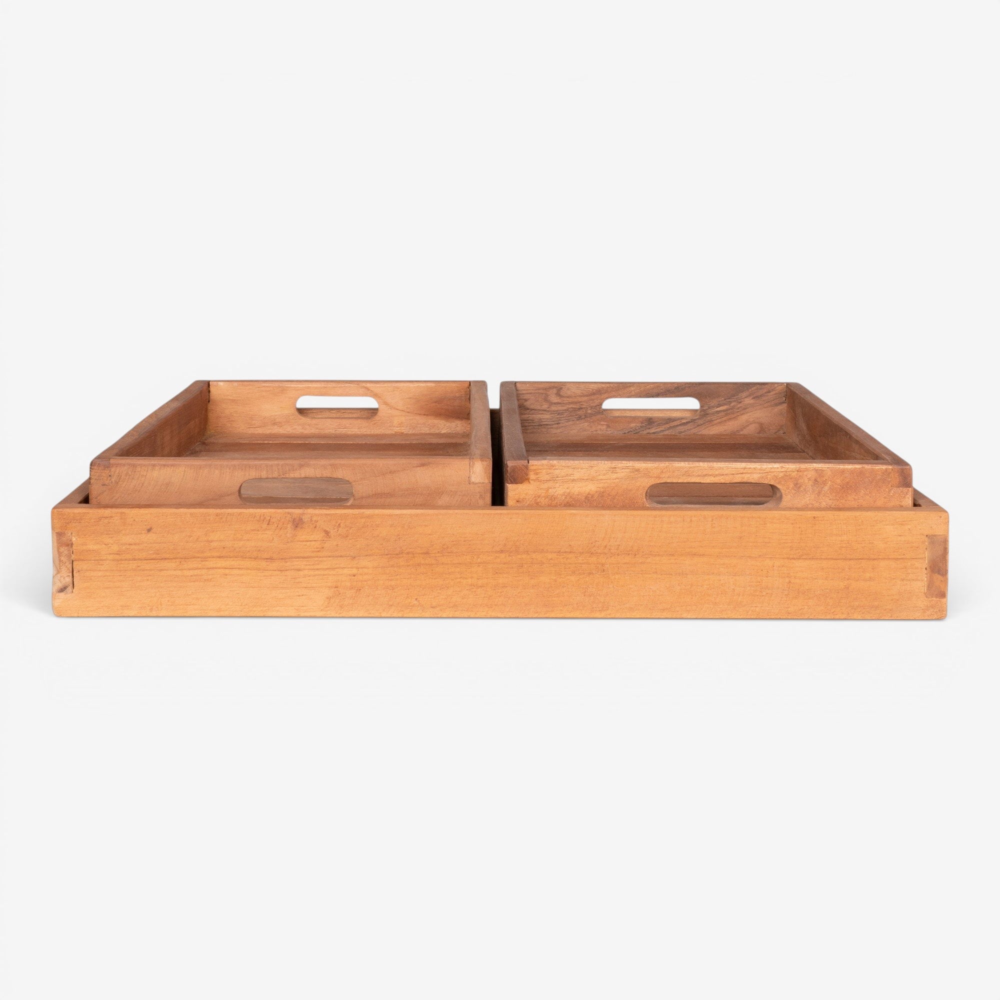 Kayu Living set of 3 natural teak serving trays with cut-out handles and warm grain finish.