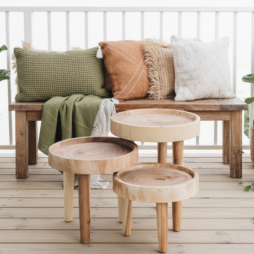 Kayu Living Ulu side table crafted from suar wood with a unique grain pattern and three legs. Natural wood finish.