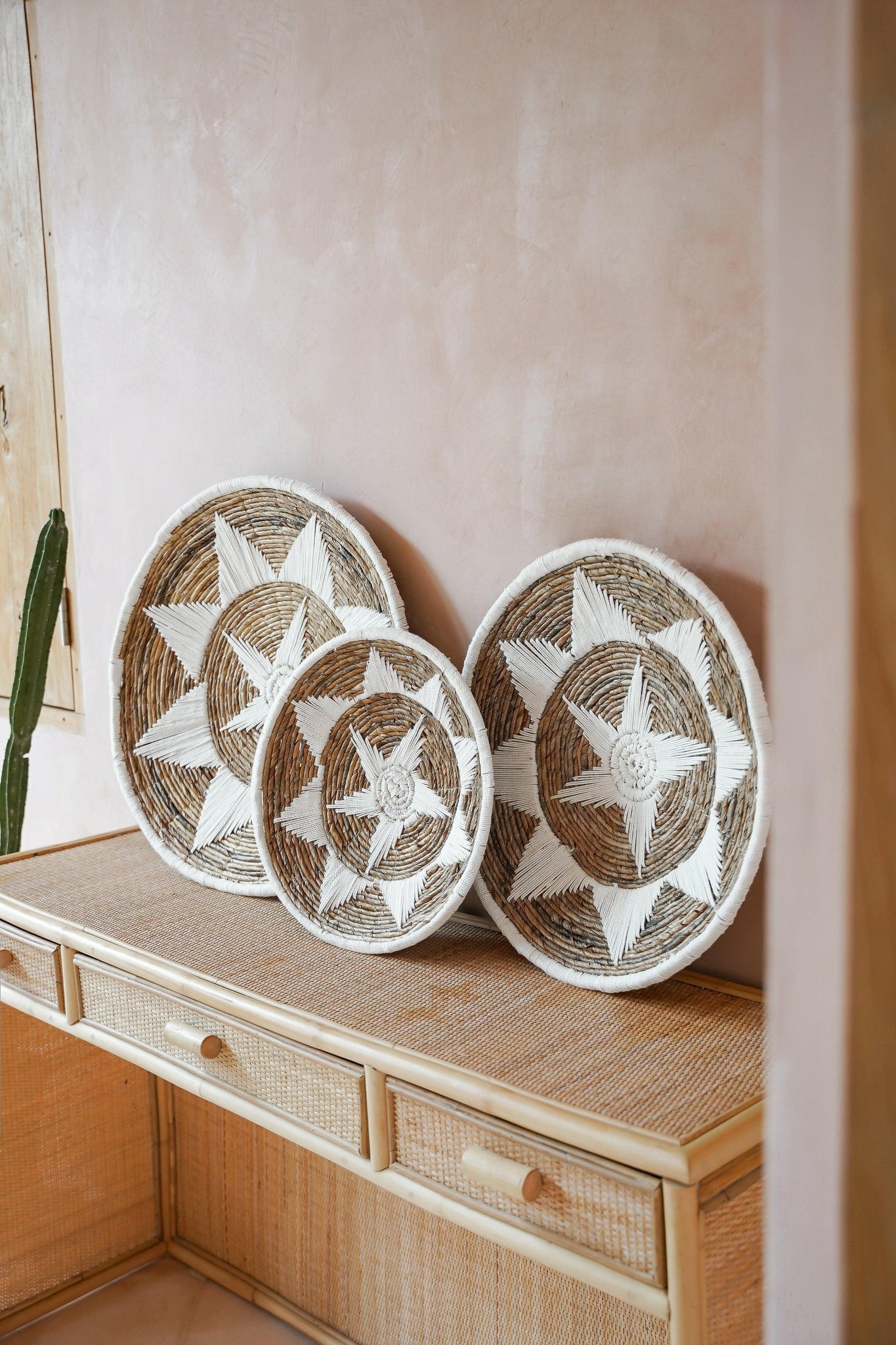 Kayu Living Uluwatu handmade banana-leaf and cotton wall baskets with brown and white star patterns on a rattan console