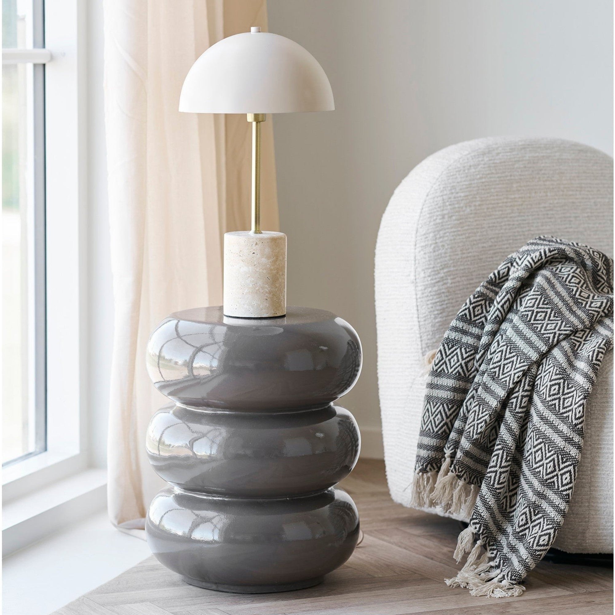 Kayu Living Adana brown plaid recycled cotton throw blanket draped over a modern white armchair