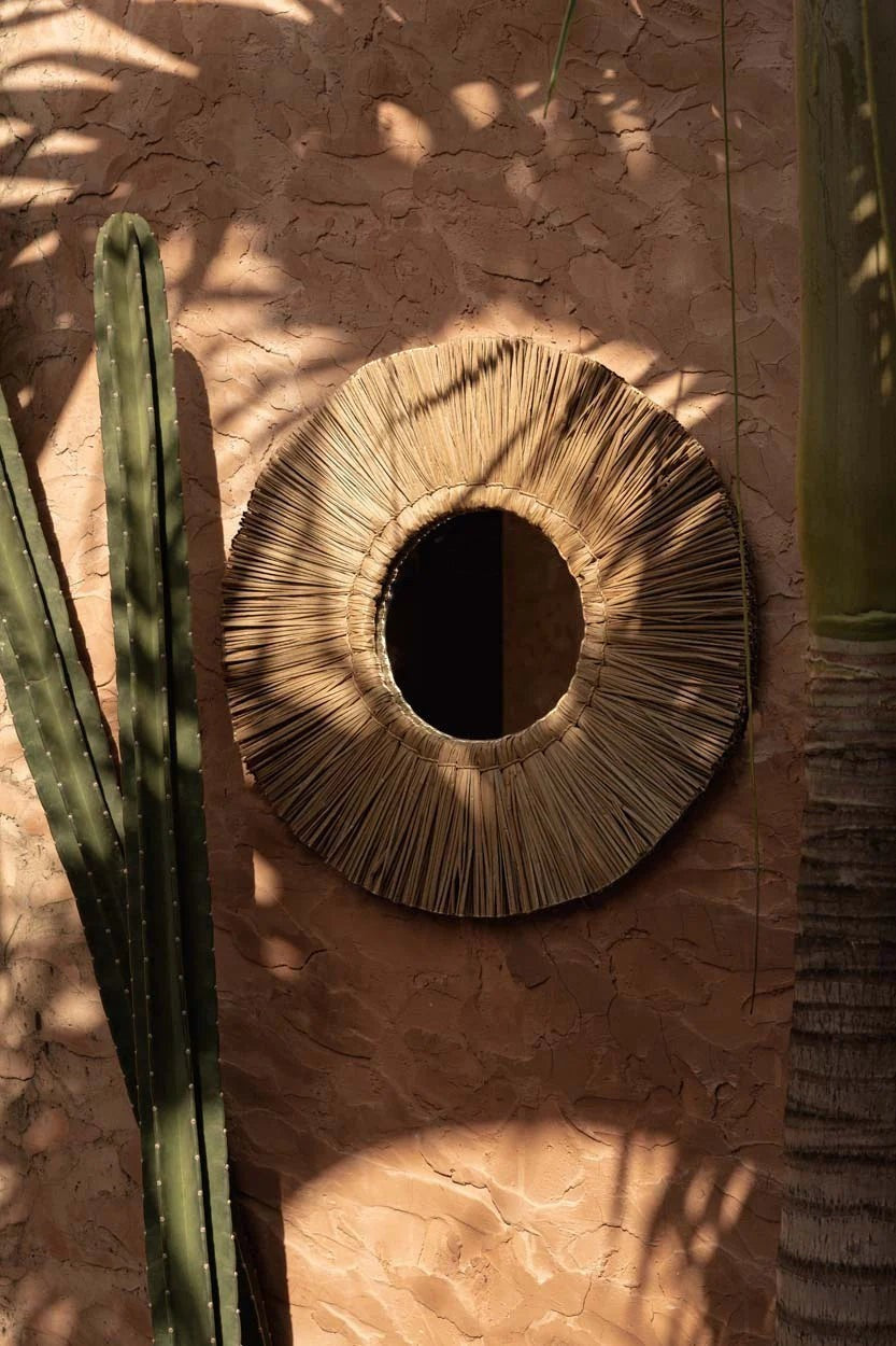 Kayu Living Alang Alang round mirror with natural grass fringe and central reflective surface, boho coastal decor.