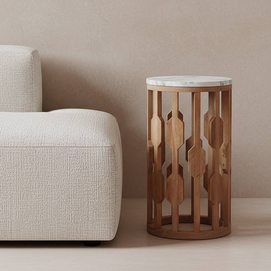 Kayu Living Atjeh side table with a round white marble top and a decorative open mango wood base next to a sofa.