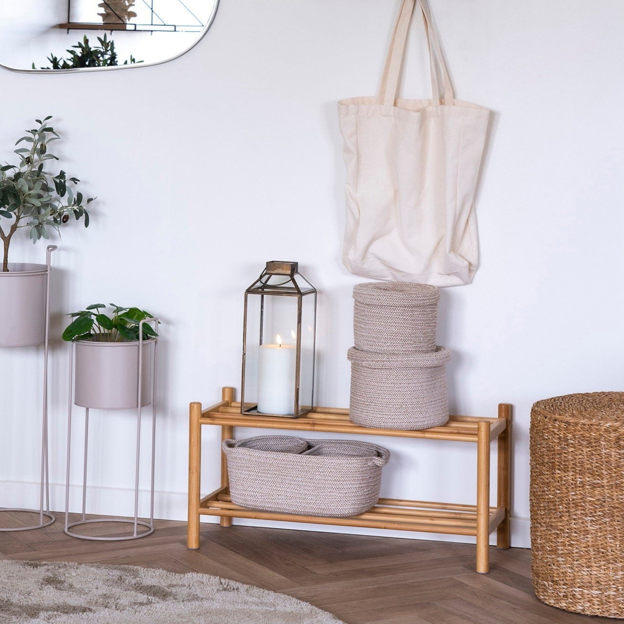 Kayu Living natural bamboo shoe rack with two shelves, holding baskets and a lantern.