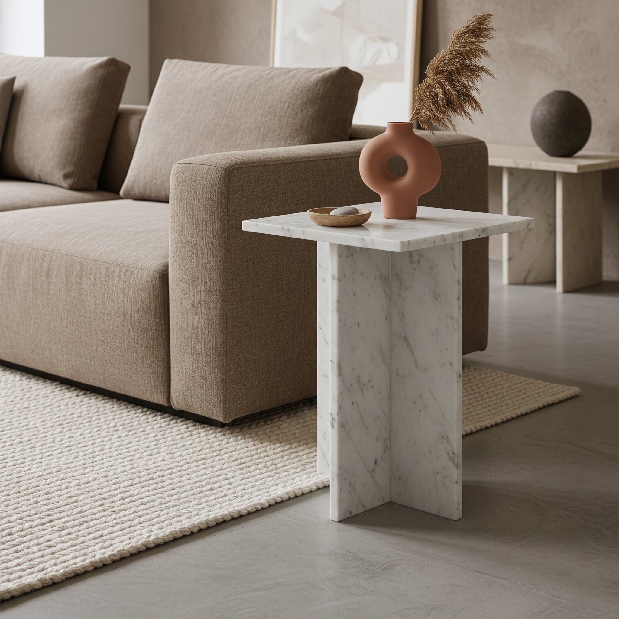 Kayu Living white marble side table with crossed slab base, featuring grey veining, styled next to a beige sofa.