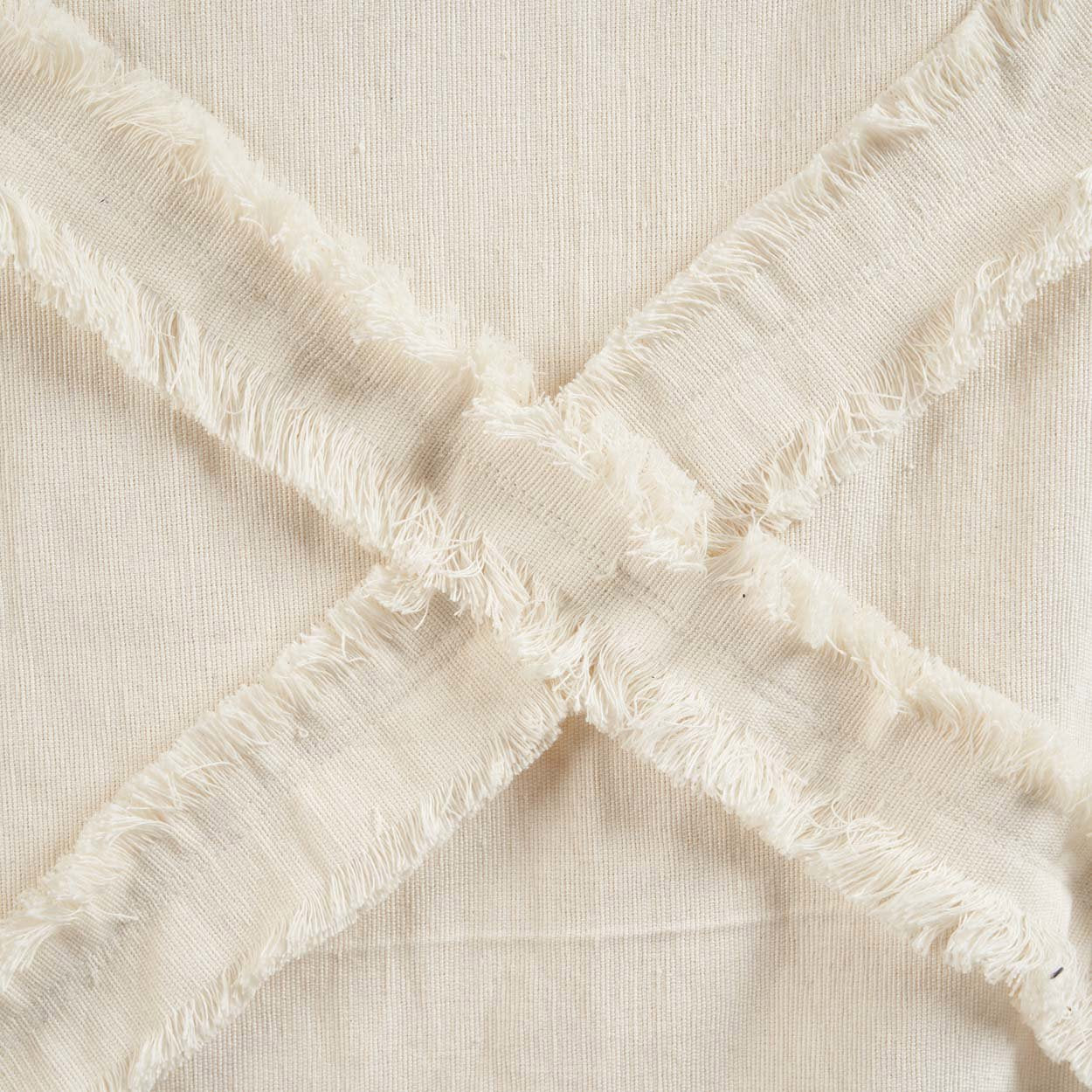 Kayu Living Berber Bed Throw in natural cotton with a soft, plush texture and decorative frayed cross-stitch detail.