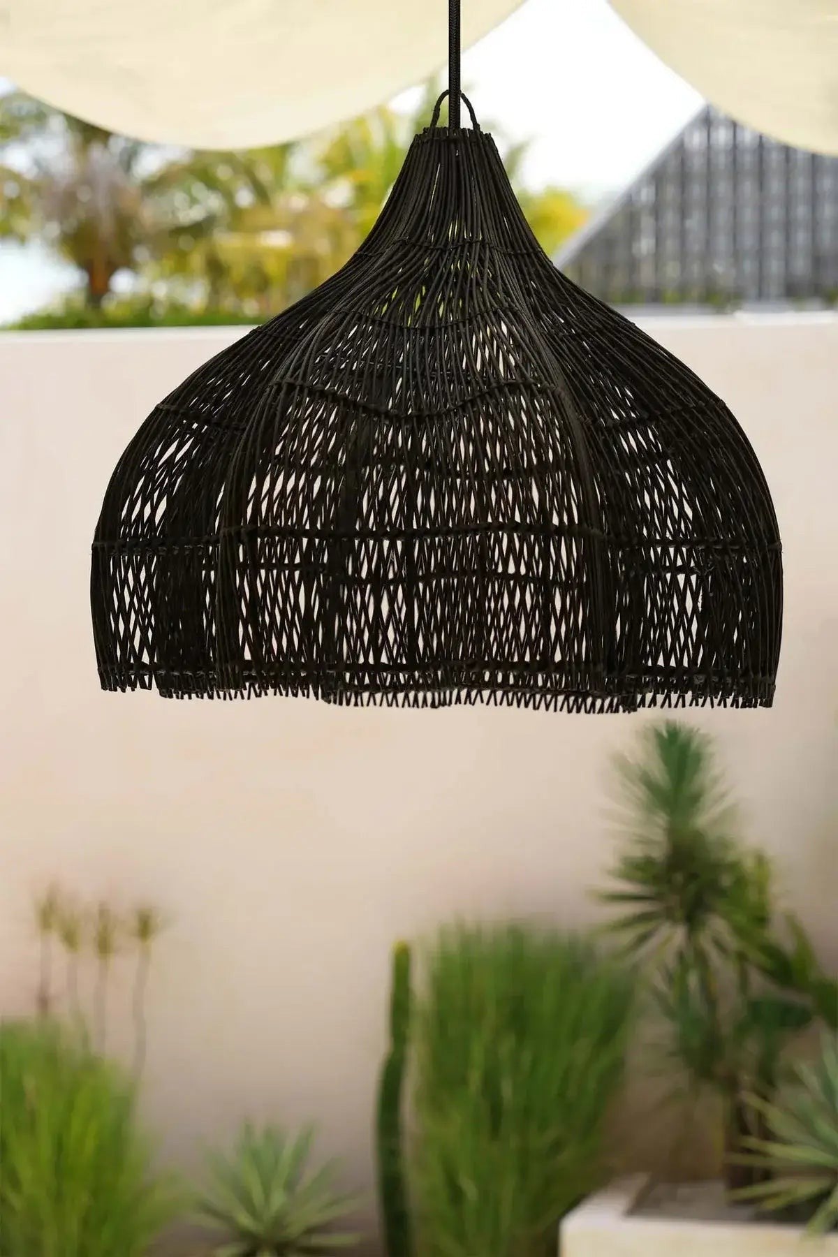 Kayu Living black rattan pendant lamp with a boho style and unique shape. Ideal for indoor or outdoor spaces.