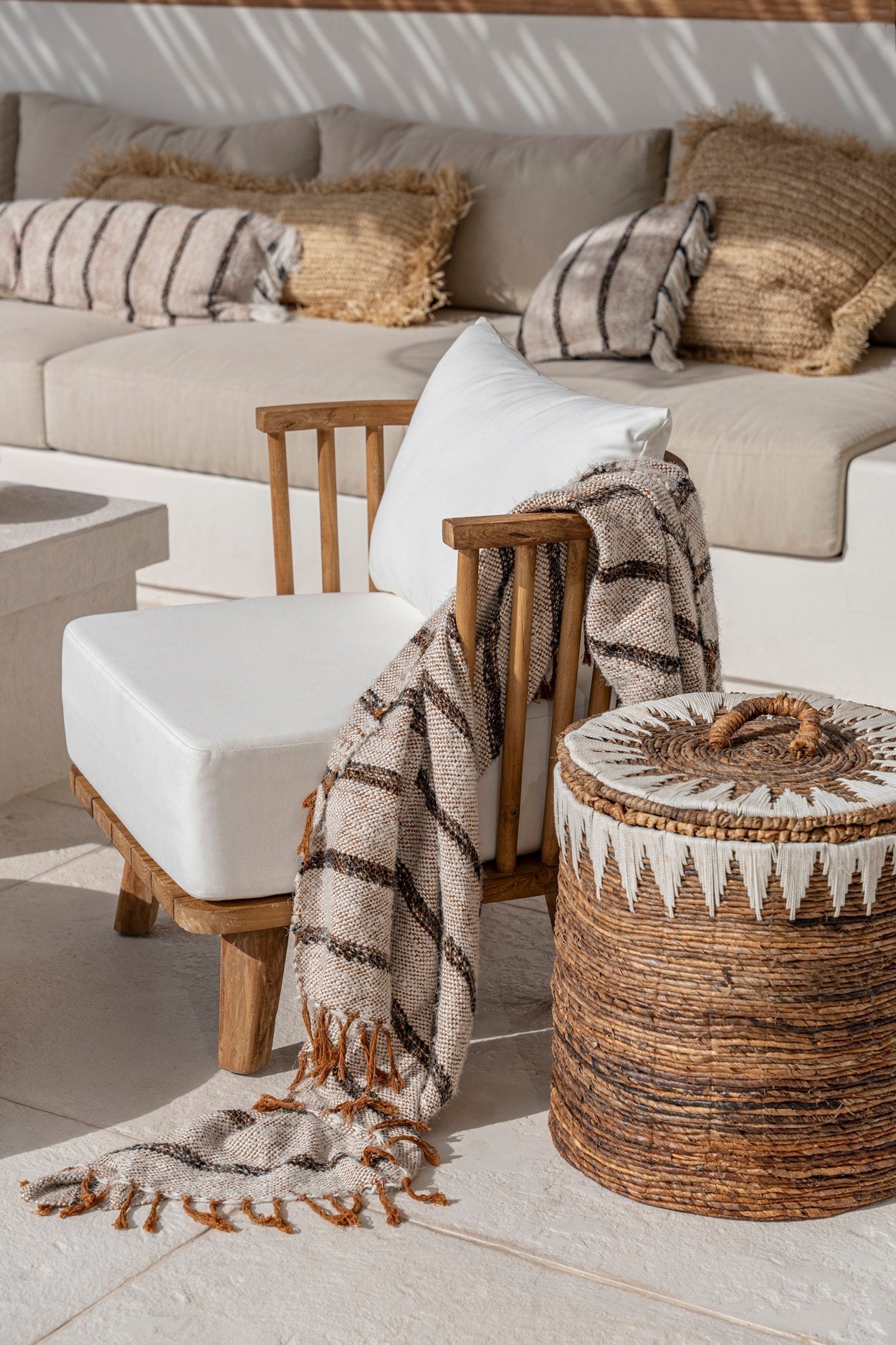 Kayu Living Bohemian White hand-woven cotton plaid throw with fringed edges and waffle texture draped on a chair.