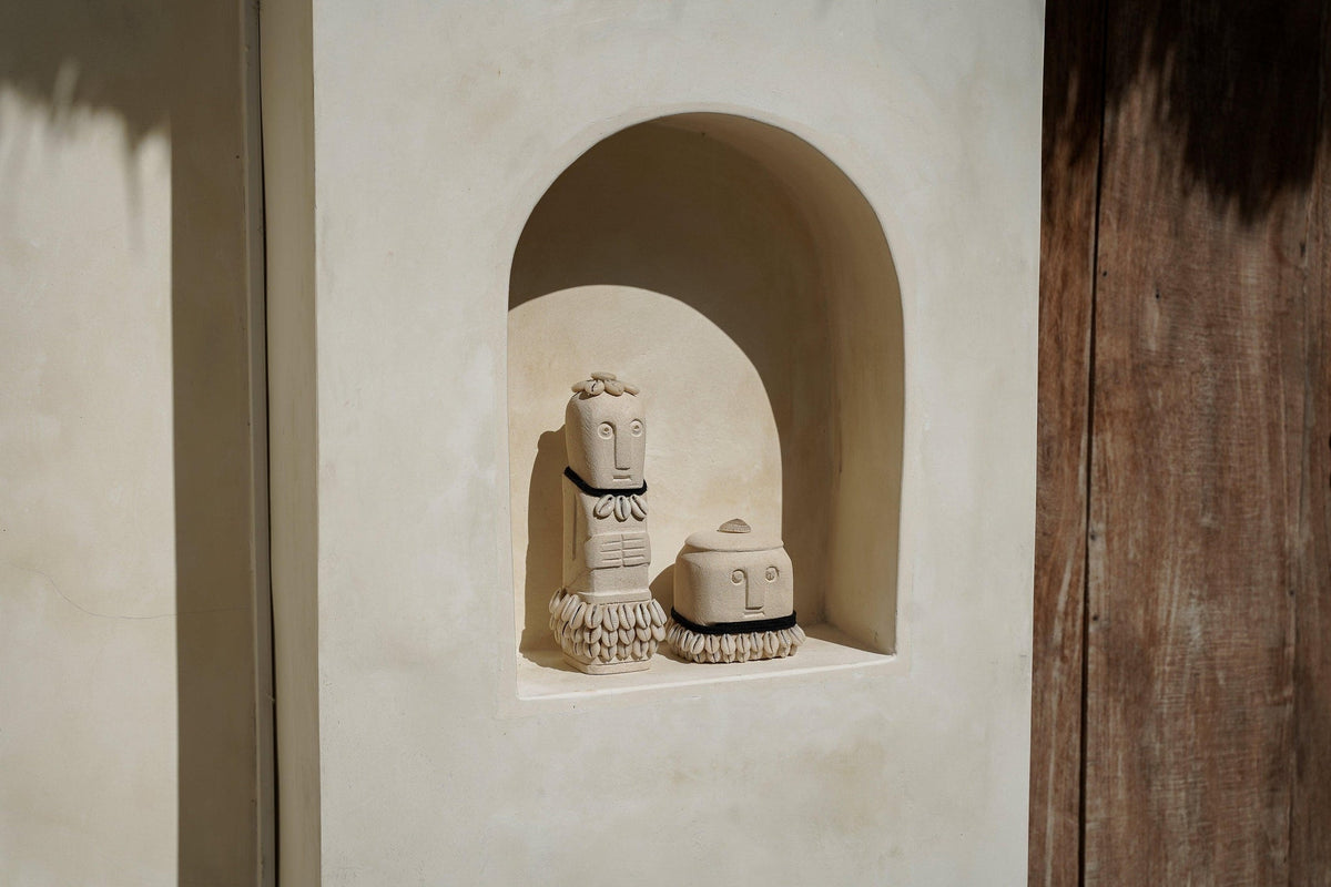 Kayu Living handmade Boho Stone Men figurine set in natural beige stone with decorative black accents on a shelf.
