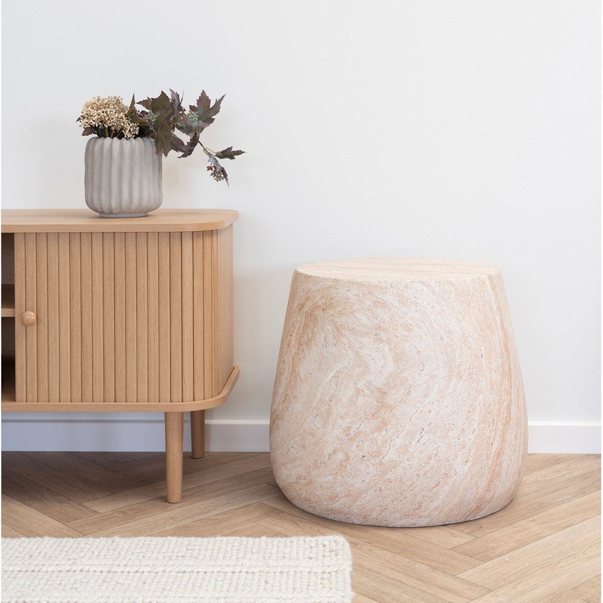 Kayu Living Bonn side table in natural fiberclay with a stone-like finish, placed in a minimalist living room.