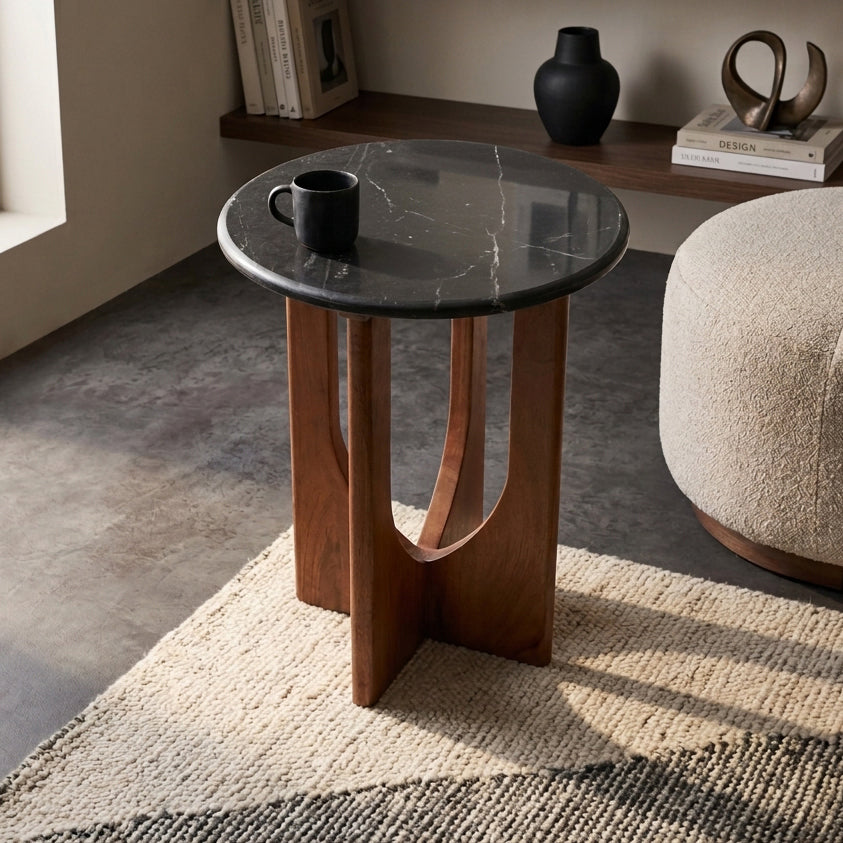 Kayu Living Brunei side table with a round black marble top and a dark mango wood cross base in a modern living room.