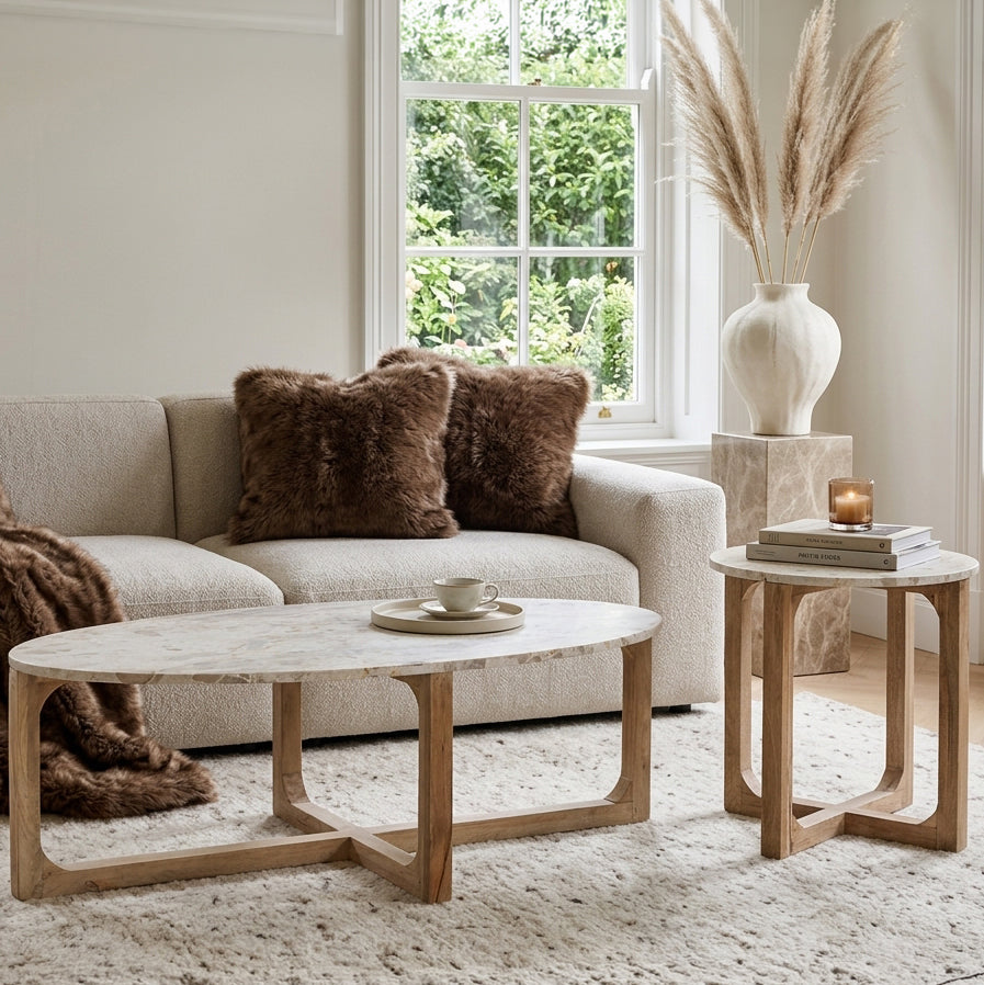 Kayu Living cream marble side table with a round top and natural mango wood base in a bright living room setting.