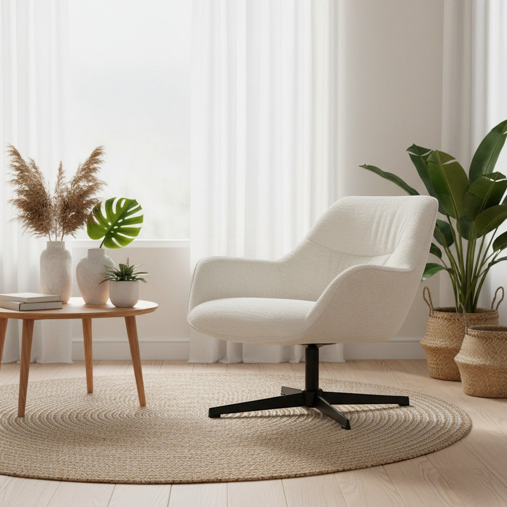A modern upholstered swivel armchair in off-white textured fabric with a black four-star base, placed in a bright, neutral-toned living room setting on a round woven rug next to a small wooden side table and potted plants.