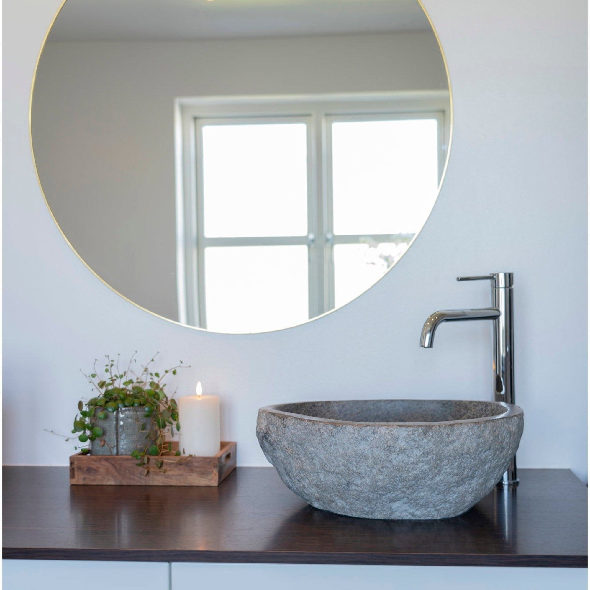 Kayu Living Donau riverstone sink with natural grey texture on a dark vanity with a modern chrome faucet and mirror.