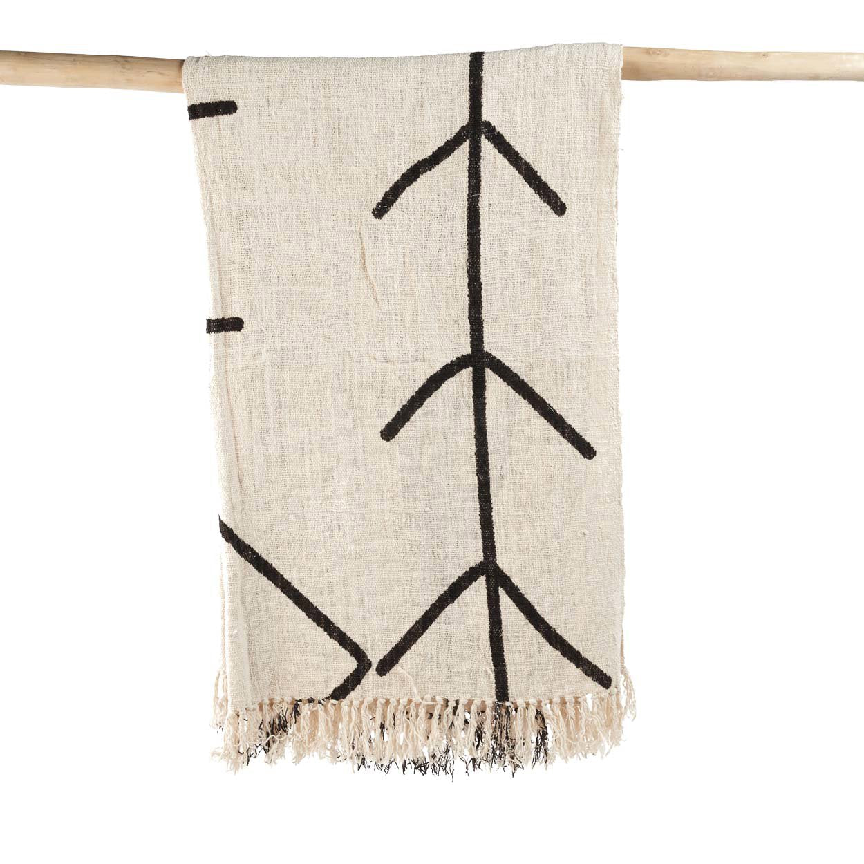 Kayu Living natural black cotton bed throw with evil eye pattern and fringe detail hanging on a wooden rail